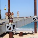 A crane lowering a prefabricated building module into place on a construction site