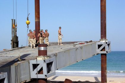 A crane lowering a prefabricated building module into place on a construction site